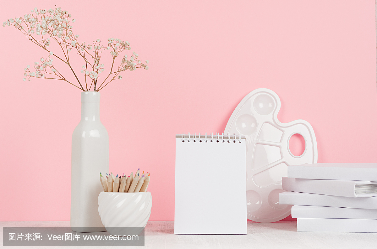 为女孩的创意学校背景-白色文具,调色板,铅笔和空白记事本在软粉色的墙壁和白色的木头书桌。